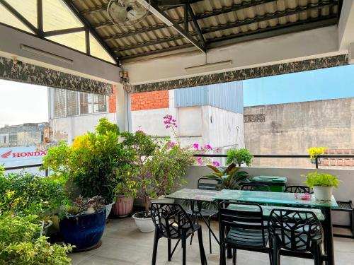 a patio with tables and chairs and potted plants at HT Hotel Apartment in Ho Chi Minh City