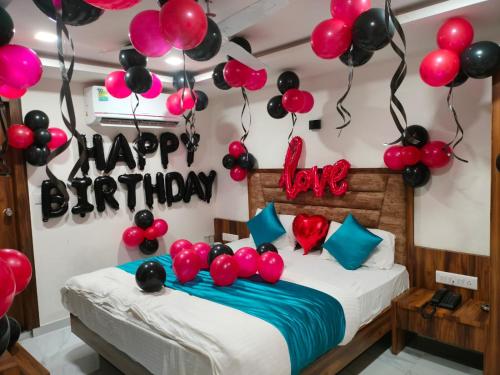 ein Zimmer mit einem Bett mit Ballons und einem Happy Birthday-Schild in der Unterkunft Hotel Angell Park in Ahmedabad