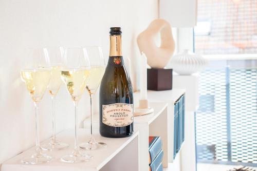 a bottle of wine sitting on a shelf with wine glasses at ※Luxus Loft mit Boxspringbetten und Heimkino ※ in Inzlingen