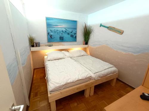 a small bed in a room with a painting on the wall at Panoramic App A07-6 in Sierksdorf