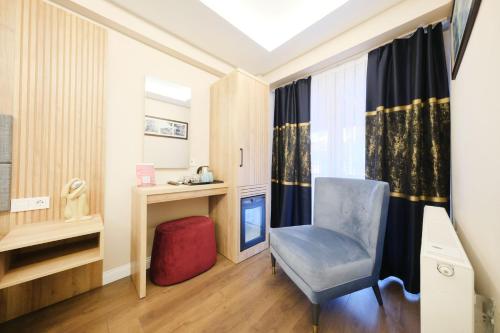 Camera con sedia, scrivania e finestra. di Hotel Martin a Istanbul