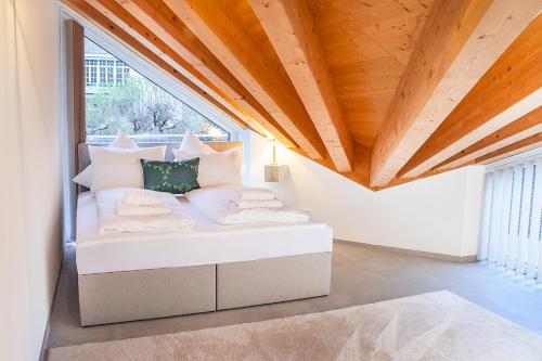 Bett in einem Zimmer mit Holzdecke in der Unterkunft ※Luxus Loft mit Boxspringbetten und Heimkino ※ in Inzlingen