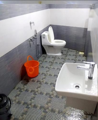 a bathroom with a white toilet and a sink at Tharavad Residency in Iritti