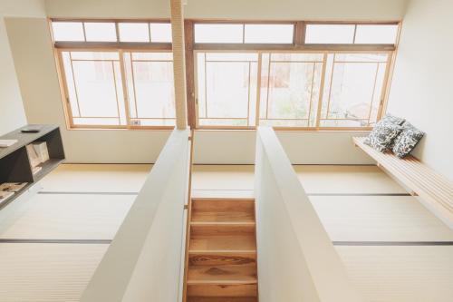 a room with a staircase and two windows at Une stay&diner in Sasayama