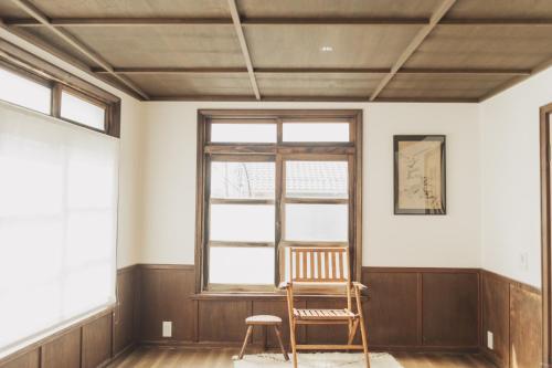 an empty room with a chair and a window at Une stay&diner in Sasayama