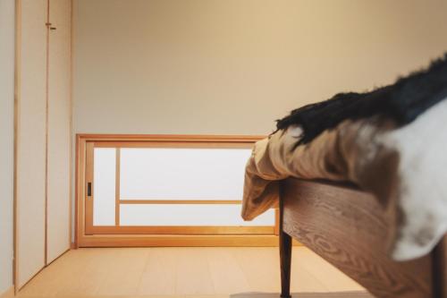a window in a room with a bed in front of it at Une stay&diner in Sasayama