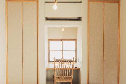 a dining room with a table and a chair at Une stay&diner in Sasayama