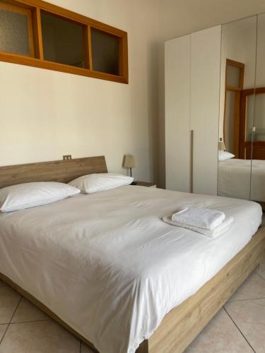 a bedroom with a large white bed and a mirror at da zia Emanuela in Ottaviano
