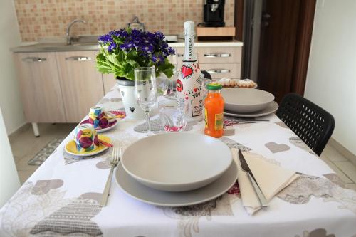 a table with plates and utensils on top of it at CasApulia - Bari Airport apartment in Bitonto