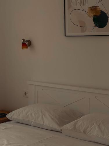 a white bed with a picture on the wall at M&N Residence Tivat in Tivat