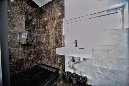 a bathroom with a sink and a shower with plants at GaujaClub - our BOSE and Bang&Olufsen lofts on a lake in Gauja