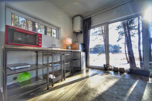 a living room with a tv and a large window at GaujaClub - our BOSE and Bang&Olufsen lofts on a lake in Gauja