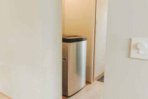 a trash can sitting next to a refrigerator at Une stay&diner in Sasayama
