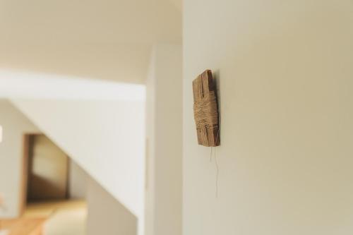 a piece of wood hanging on a white door at Une stay&diner in Sasayama