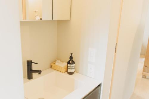 a kitchen counter with a sink and a bottle of wine at Une stay&diner in Sasayama