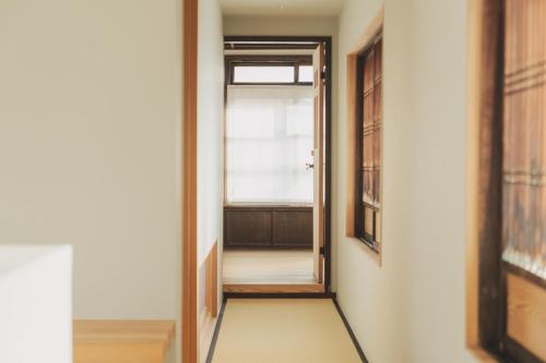 an empty hallway with a door and a window at Une stay&diner in Sasayama