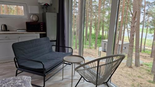 a living room with a chair and a table at GaujaClub - our BOSE and Bang&Olufsen lofts on a lake in Gauja