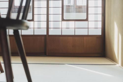 a room with a window and a chair in front of it at Une stay&diner in Sasayama