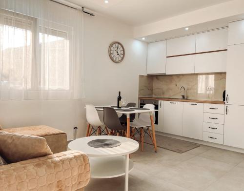 Una cocina y una sala de estar con un sofá y una mesa. en M&N Residence Tivat, en Tivat