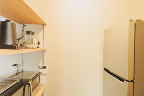 a refrigerator in a kitchen next to a counter at Une stay&diner in Sasayama