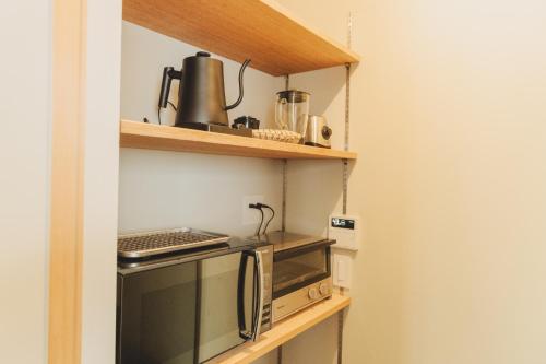 a kitchen with a stove and a microwave at Une stay&diner in Sasayama