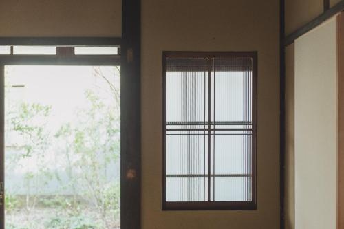 a room with a window with blinds on it at Une stay&diner in Sasayama
