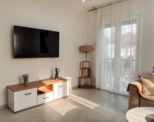a living room with a tv on a white wall at M&N Residence Tivat in Tivat