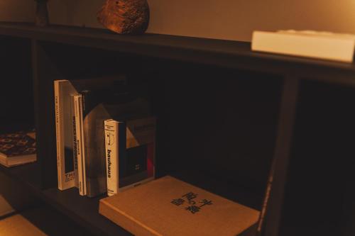 a book shelf filled with books on top at Une stay&diner in Sasayama