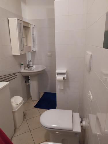 Baño blanco con aseo y lavamanos en Casa facile, en Monteroni di Lecce