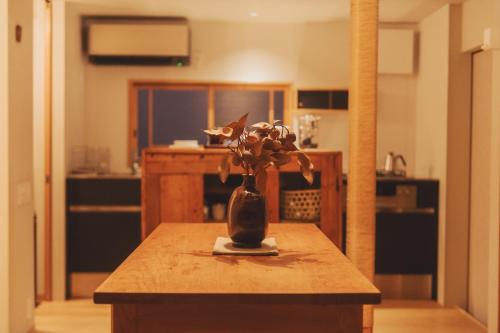a vase with flowers on a table in a kitchen at Une stay&diner in Sasayama