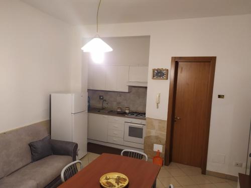sala de estar con sofá, mesa y cocina en Casa facile, en Monteroni di Lecce