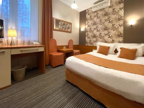 een hotelkamer met een groot bed en een bureau bij Eney Budget in Lviv