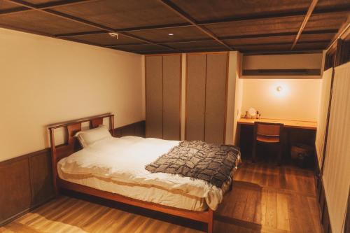 a bedroom with a bed and a desk at Une stay&diner in Sasayama