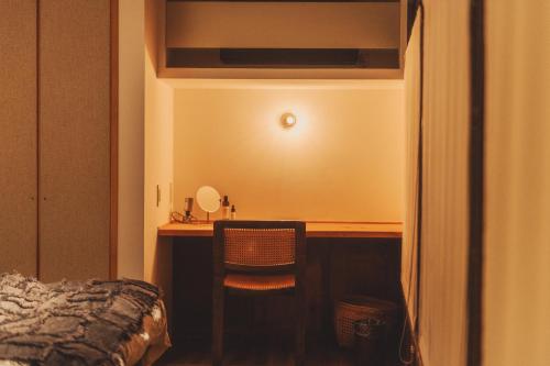 a bedroom with a desk with a chair and a bed at Une stay&diner in Sasayama