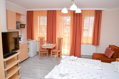 a living room with two beds and a kitchen at Major Panzió és Étterem in Hajdúszoboszló