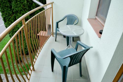 two chairs and a table on a balcony at Major Panzió és Étterem in Hajdúszoboszló