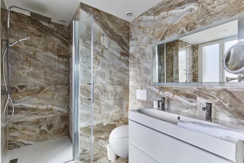 y baño con ducha acristalada y lavamanos. en Appartement Rolland Garros, Parc des Princes by Studio prestige, en Boulogne-Billancourt