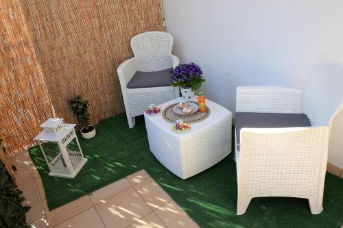 two chairs and a table on a patio at CasApulia - Bari Airport apartment in Bitonto