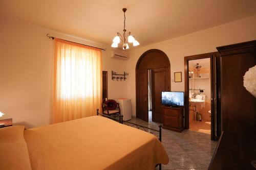 1 dormitorio con 1 cama y TV de pantalla plana en Salento Terra Maris en Cocumola