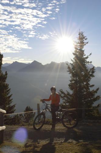 a person standing with a bike on a hill at Pension Panorama in San Lorenzo di Sebato