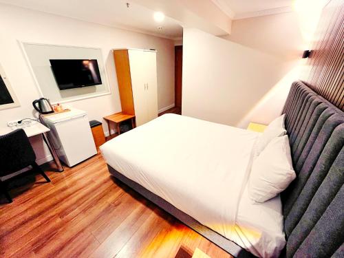 伊斯坦堡的住宿－奈拉酒店，酒店客房设有白色的床和电视。