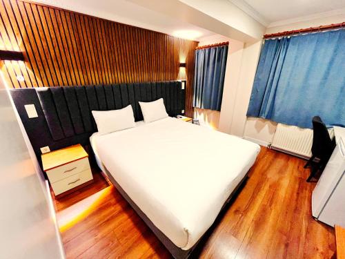 イスタンブールにあるNaila Hotelのウッドフロアのベッドルーム1室(大きな白いベッド1台付)