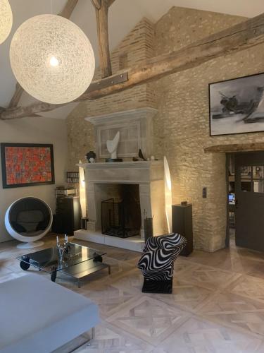 a living room with a couch and a fireplace at Le Clos 1855 in Saint-Laurent-des-Bâtons