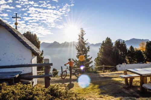 a person riding a bike next to a house at Pension Panorama in San Lorenzo di Sebato
