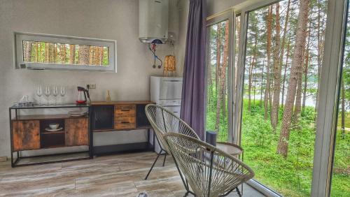 a kitchen with a table and chairs in front of a window at GaujaClub - our BOSE and Bang&Olufsen lofts on a lake in Gauja