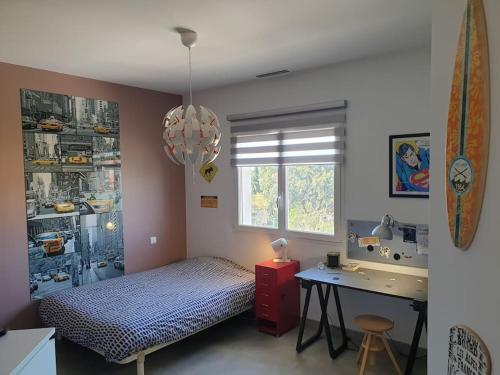 une chambre avec un lit, un bureau et un lavabo dans l'établissement Belle villa, piscine et cigales au calme !, à Saint-Jean-de-Védas