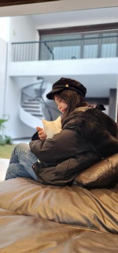 a woman sitting on a bed holding a cat at Homstay Hoa Ban in Dien Bien Phu