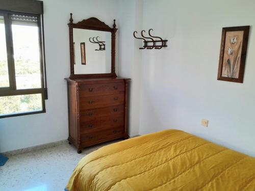 a bedroom with a bed and a dresser and a mirror at Casa Adriana con parking Habitacion en apartamento compartido in Almuñécar