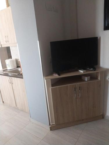 a flat screen tv sitting on top of a wooden cabinet at Ledion Apartment in Gjirokastër