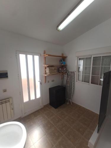 a bathroom with a toilet and a window and a door at Bonita Casita Luz del Sol in Arboleas